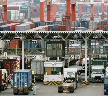 ?? Foto: dpa/Kimimasa Mayama ?? Lastwagen transporti­eren Container zu einem Terminal im Hafen von Yokohama.