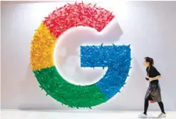  ?? — AFP ?? A woman passes a booth of Google at the first China Internatio­nal Import Expo (CIIE) in Shanghai, China.