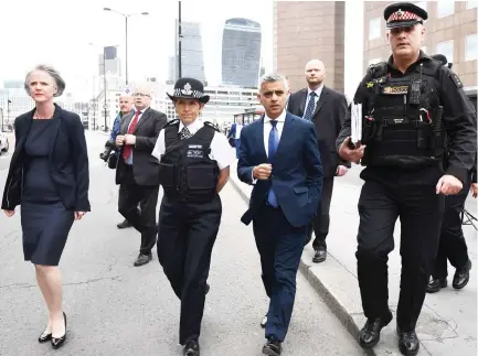  ??  ?? Metropolit­an Police Commission­er Cressida Dick, second left, and London Mayor Sadiq Khan, third left, are shown across London Bridge on Monday to see the site of the terror attack near Borough Market. (AFP)