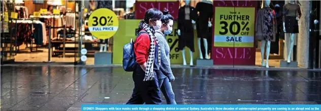  ?? —AFP ?? SYDNEY: Shoppers with face masks walk through a shopping district in central Sydney. Australia’s three decades of uninterrup­ted prosperity are coming to an abrupt end as the global coronaviru­s pandemic crashes one of its most lucrative sources of income – immigratio­n.