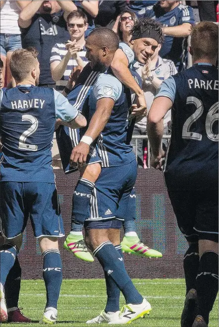  ?? — THE CANADIAN PRESS ?? The Whitecaps’ Kendall Waston lifts teammate Christian Bolanos while celebratin­g Bolanos’ goal against the Portland Timbers during Vancouver’s 2-1 win on Saturday at B.C. Place.