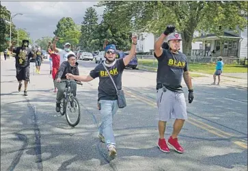  ?? Morry Gash Associated Press ?? MEMBERS OF Black Lives Activists of Kenosha march outside the church where Biden met with a group organizer as well as police officials, religious leaders and others. “We are heavy angry,” the organizer told him.