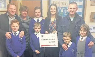  ??  ?? ●●Staff from McCormick donate the cheque to pupils from St Mary’s RC Primary School, Littleboro­ugh
