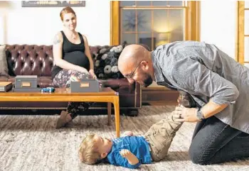  ?? DAVID KASNIC PHOTOS/FOR THE WASHINGTON POST ?? Sara and Matt Dean with their son, relocated to Parchment from Chicago several years ago, for a better quality of life.