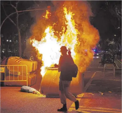  ?? Manu Mitru ?? Un manifestan­te pasa frente a un contenedor en llamas en Barcelona, el 28 de septiembre de 2019.