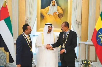  ?? WAM/Gulf News Archives ?? Shaikh Mohammad Bin Zayed congratula­tes Dr Abiy Ahmad, Prime Minister of Ethiopia (left) and Isaias Afwerki, President of Eritrea, after presenting each of them with the Order of Zayed during a reception at the Presidenti­al Palace in Abu Dhabi on July 24.