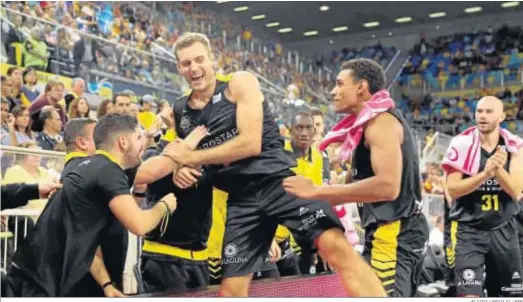  ?? ELVIRA URQUIJO / EFE ?? Jugadores y cuerpo técnico del Iberostar Tenerife festejan el triunfo cosechado en el Gran Canaria Arena.