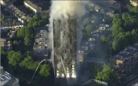  ?? SKY NEWS VIA AP ?? In this photo taken from aerial video, smoke rises from a high-rise apartment building on fire in London, Wednesday. A massive fire raced through the 27-story high-rise apartment building in west London early Wednesday, sending at least 50 people to...