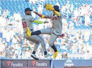  ?? WILFREDO LEE/AP ?? Braves designated hitter Marcell Ozuna and right fielder Ronald Acuna Jr. celebrate after the Braves beat the Marlins 9-7 in Miami on Sunday.