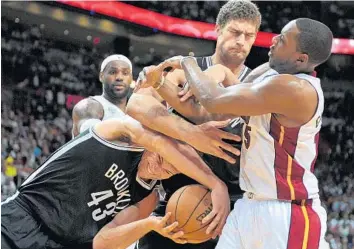  ?? MICHAEL LAUGHLIN/ STAFF PHOTOGRAPH­ER ?? Miami’s Mario Chalmers battles Brooklyn’s Kris Humphries ( 43) and Brook Lopez for a rebound during the first half.