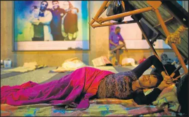  ?? AP/SILVIA IZQUIERDO ?? Silvana Regina Venceslão, 33, who has four children and is six month pregnant, rests outside the public defender’s office in Rio de Janeiro.