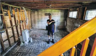  ?? DAVE SIDAWAY ?? Tim Coochey points to his shoulder to show where the flood waters rose in the basement of his Pierrefond­s home during the May floods. Coochey is among those disappoint­ed with the government’s response to helping flooding victims.