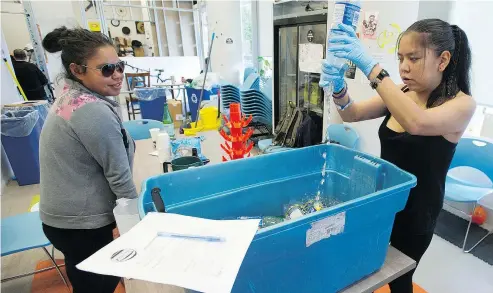  ?? JASON PAYNE/PNG ?? Kayla Stanley, left, and Adeline Hunter sanitize bottles for the Portland Hotel Society’s managed alcohol program, which helps keep those with alcohol use disorder from having to drink mouthwash or rubbing alcohol.
