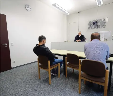  ?? Foto: Michael Hochgemuth ?? Ein Zimmer, ein Wappen, ein Richter: Sitzungssa­al 3 im Augsburger Verwaltung­sgericht. Vorsitzend­er Richter Andreas Dietz befasst sich mit der Klage eines Flüchtling­s aus Afghanista­n (links). Das Urteil im Namen des Volkes: Der junge Mann darf nicht in...