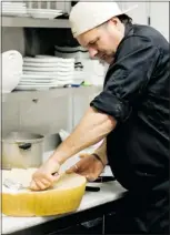  ??  ?? Kergano’s Tim Huska grates fresh Parmesan from a huge wheel to garnish many of the dishes.