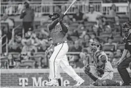  ?? BRETT DAVIS USA TODAY NETWORK ?? Braves batter Travis d'Arnaud hits a grand slam against the Rangers during the sixth inning Friday in Atlanta.