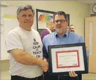  ?? MILLICENT MCKAY/JOURNAL PIONEER ?? Mark Ronahan, left, receives his P.E.I. Learning Disabiliti­es Associatio­n/ Staples Educator of the Year award from Rod Callahan of Staples Charlottet­own.