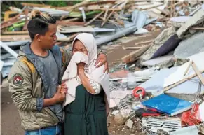  ?? — Reuters ?? All gone: A woman reacting after seeing her destroyed home in Cianjur.