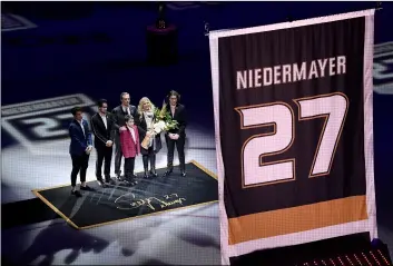  ??  ?? Former Anaheim Ducks defenseman Scott Niedermaye­r watches along with his family as his jersey is retired prior to an NHL hockey game between the Ducks and the Washington Capitals in Anaheim, Calif.