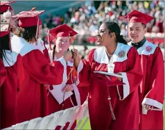  ?? SARAH GORDON/THE DAY ?? Maltide Portes fist-bumps a classmate after receiving her diploma Wednesday, during Norwich Free Academy’s commenceme­nt ceremony.