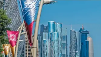  ?? ?? FROM OPPOSITE PAGE: Lusail Stadium; Doha’s metro serves 37 stations over 37km; flags advertisin­g the Expo 2023 event