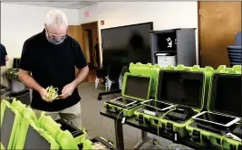  ?? PHOTOS BY HANS PENNINK — THE ASSOCIATED PRESS FILE ?? Mark Splonskows­ki assembles electronic pollbook kits that voters will use to sign in at polling locations at the Albany County Board of Elections building in Albany, N.Y., Oct. 14, 2020.