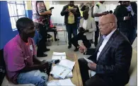  ??  ?? President Jacob Zuma receives his ballot paper to cast his vote at Ntolwane Primary School in Nkandla.