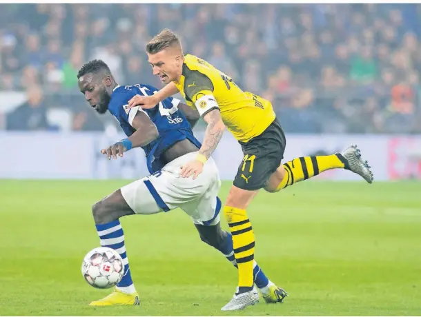  ?? FOTO: BERND THISSEN/DPA ?? Nach einem Jahr Pause wieder da: das Revierderb­y (hier Schalkes Salif Sane (l.) und Dortmunds Marco Reus 2018.