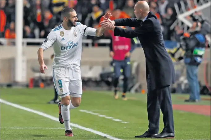  ??  ?? FELICITACI­ÓN MUTUA. Zidane felicitó a Benzema cuando éste se dirigía hacia el banquillo para celebrar su primer gol de la noche con Borja Mayoral.