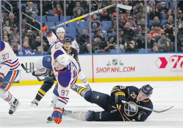  ?? — THE ASSOCIATED PRESS ?? Buffalo Sabres defenceman Jake McCabe, right, trips up Edmonton Oilers forward Connor McDavid during the Sabres’ 4-3 overtime win in Buffalo.