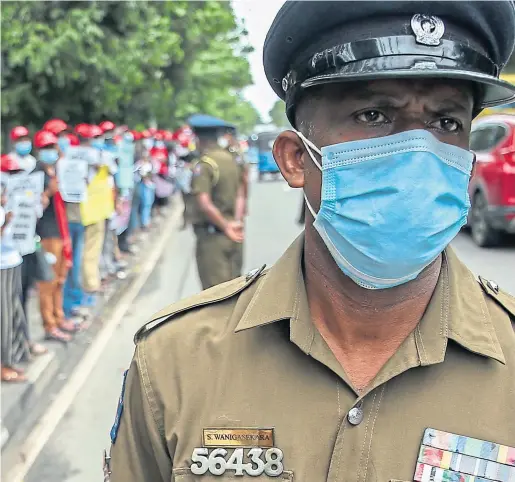  ?? Picture Pradeep Dambarage ?? A police officer stands guard as trade union members in Sri Lanka protest near the parliament in Colombo earlier this month