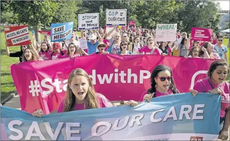  ?? [ANDREW HARNIK/THE ASSOCIATED PRESS] ?? Demonstrat­ors march around the U.S. Capitol on Wednesday as they protest against the Senate GOP’s health-care bill.