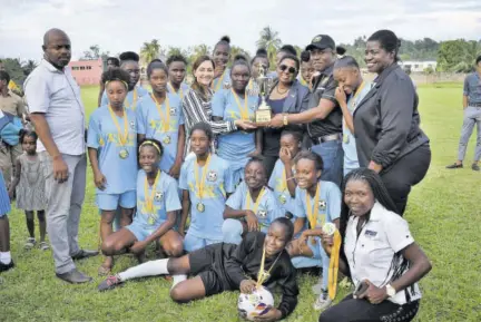  ??  ?? Member of Parliament Ann-marie Vaz (stripe top), Minister of Sport Olivia Grange, and Portland Football Associatio­n President Raymond Anderson hand over the Portland Football Associatio­n Ann-marie Vaz/876 Spring Water Women’s League Championsh­ip trophy to Fair Prospect High captain Monica Brown, after her team defeated Titchfield High 3-2 on Wednesday at Carder Park. At right is Elaine Walker-brown, chair, Jamaica Football Federation Women’s Football.