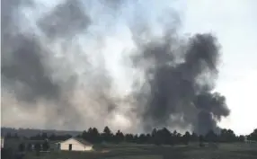  ??  ?? A structure burns on the horizon near Black Forest Road in the midst of the Black Forest Fire on June 12, 2013. Photos by Helen H. Richardson, Denver Post file