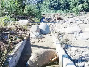  ??  ?? KEROSAKAN empangan air di Kampung Linsosod akibat banjir kilat.