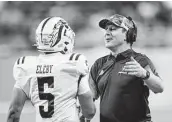  ?? Carlos Osorio / Associated Press ?? Western Michigan quarterbac­k Kaleb Eleby and coach Tim Lester celebrate a Broncos touchdown.