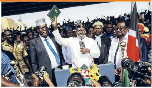  ??  ?? Opposition leader Raila Odinga holds up a bible during his “swearing-in” ceremony