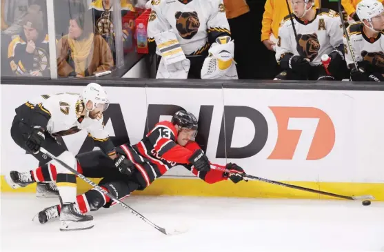  ?? MARY SCHWALM/AP ?? Blackhawks forward Max Domi lunges for the puck as he falls to the ice against the boards ahead of Bruins forward Nick Foligno in the first period.