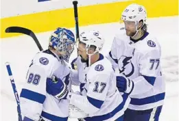  ?? FRANK GUNN/AP ?? Lightning goaltender Andrei Vasilevski­y (88) and teammates Alex Killorn (17) and Victor Hedman (77) celebrate a 7-1 win over the Bruins in Game 3 on Wednesday.