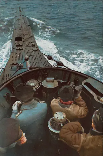  ??  ?? ■ A spectacula­r photograph taken on board U-553 in 1942. On the very far right, with his arm resting on the mount of the UZO, the U-boot-ziel-optik (U-boat targeting optics), is Kapitänleu­tnant Thurmann wearing his characteri­stic leather jacket. The metal badge in the shape of a tortoise can be seen on his forage cap and is the insignia of U-553. (Coloured by RJM)