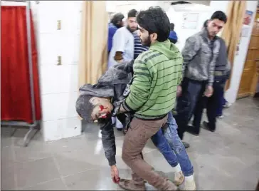  ?? AMER ALMOHIBANY/AFP ?? A man carries a wounded Syrian at a make-shift hospital in Kafr Batna following Syrian government bombardmen­ts on the besieged Eastern Ghouta region, on the outskirts of Damascus, on Wednesday.