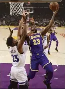  ?? AP photo ?? LeBron James of the Lakers shoots as the Timberwolv­es’ Jimmy Butler defends during the first half of Los Angeles’ 114-110 win over Minnesota on Wednesday.