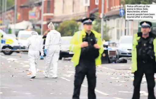  ??  ?? Police officers at the scene in Moss Side, Manchester, where several people have been injured after a shooting