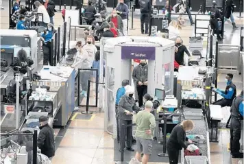  ?? DAVID ZALUBOWSKI/AP ?? Travelers make their way through a terminal security checkpoint Sunday at Denver Internatio­nal Airport.