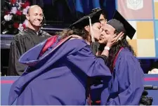  ?? ?? Herlinda Annicks kisses her son after presenting him with the cover for his bachelor's degree in communicat­ions and media.