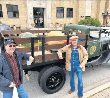  ?? PAUL EISENBERG/DAILY SOUTHTOWN PHOTOS ?? Randy Oyster, left, and John Sailor, both of Homewood, stop by the Homewood Farmers Market on Oct. 3 in Sailor’s 1931 Ford Model AA loaded with 200-plus-pound pumpkins that earned them second and third place prizes in a contest sponsored by the Cook County Farm Bureau. Alyssa Kochanny, of Romeoville, won the adult contest with a gourd that weighed in at 724 pounds.