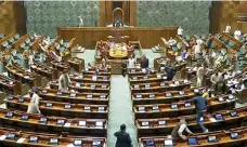  ?? AFP ?? A man, bottom right, leaps over benches of the lower house of India’s Parliament, during the security breach