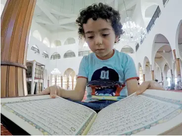  ?? Photo by M. Sajjad ?? A boy recites the Holy Quran at King Faisal Mosque in Sharjah after Asr prayers on Tuesday. —