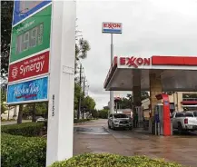  ?? Callaghan O'Hare / Bloomberg ?? Vehicles refuel at an Exxon Mobil Corp. gas station in Houston. Irving-based Exxon said Friday it lost $680 million in the quarter, three months after posting a $1 billion loss.