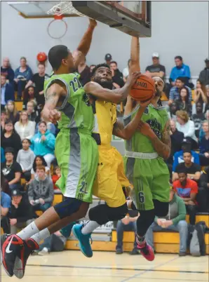  ?? NEWS PHOTO RYAN MCCRACKEN ?? Medicine Hat College Rattlers guard Jordan Wynter goes up to sink a basket while Red Deer College Kings Anthony Robbs (left) and Ian Tevis attempt to block the shot during Saturday's Alberta Colleges Athletics Conference bronze medal game at the Snake...